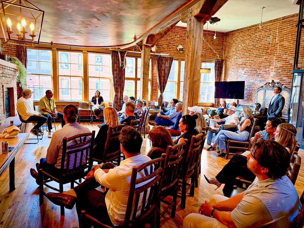 Coach Ricardo Patton beside the fireplace at The Reserve, with the room listening