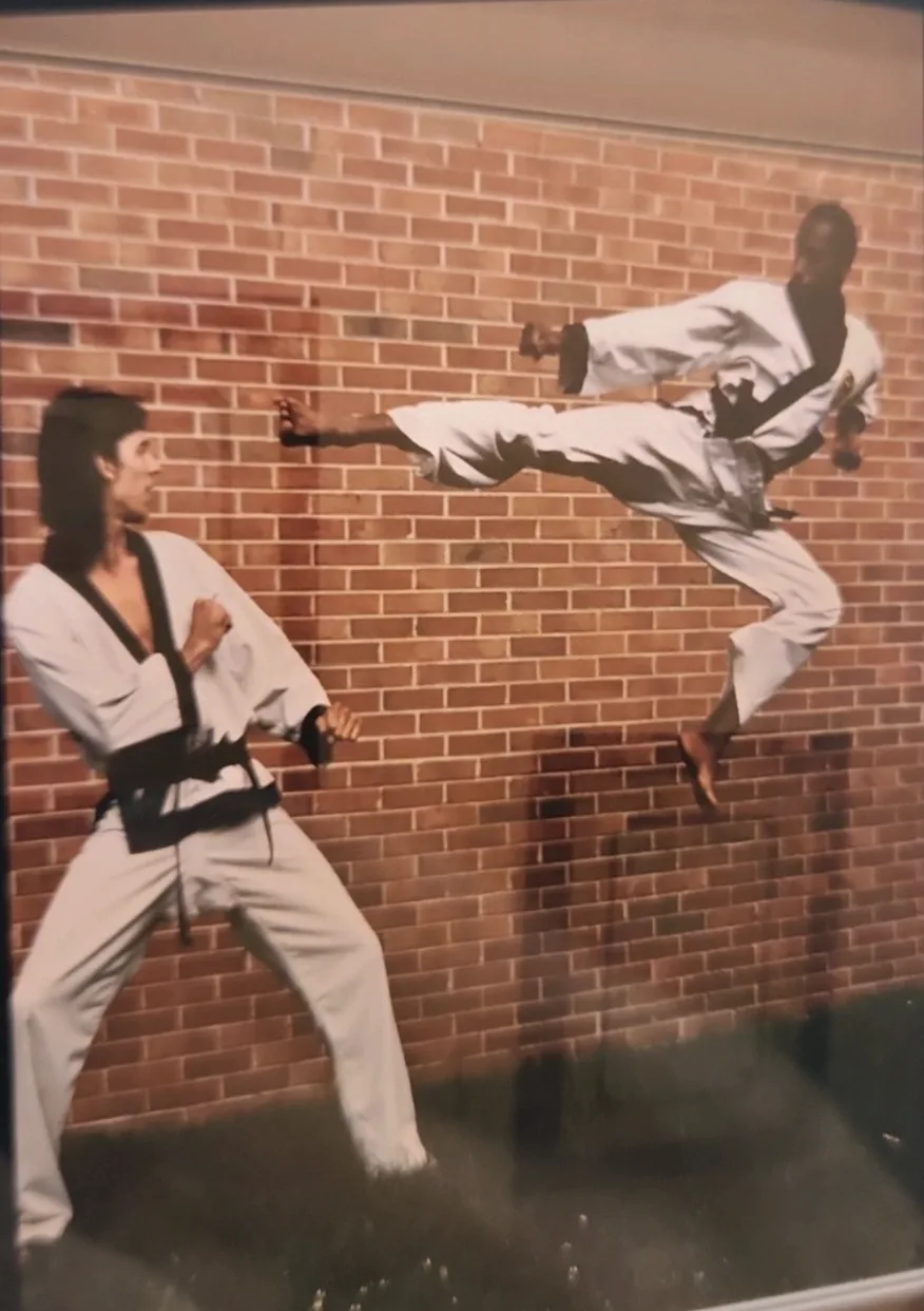 Coach Ricardo Patton mid-kick in a martial arts uniform